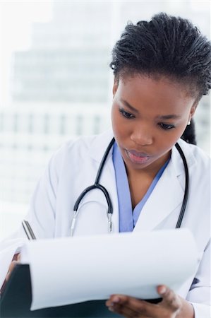 simsearch:400-06634198,k - Portrait of a young female doctor signing a document in her office Stock Photo - Budget Royalty-Free & Subscription, Code: 400-05900823