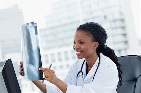 Happy female doctor looking at a set of X-rays in her office Stock Photo - Budget Royalty-Free & Subscription, Code: 400-05900832