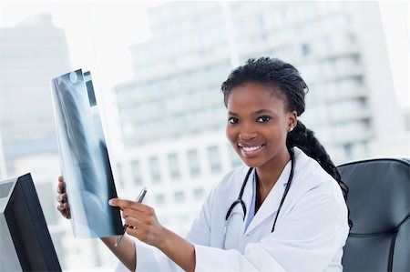 Blissful female doctor looking at a set of X-rays in her office Stock Photo - Budget Royalty-Free & Subscription, Code: 400-05900833