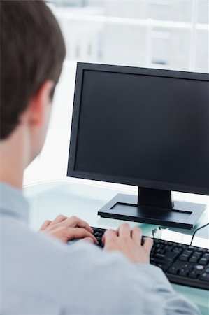 executives on table back - Back view of a businessman using a monitor in his office Stock Photo - Budget Royalty-Free & Subscription, Code: 400-05900844