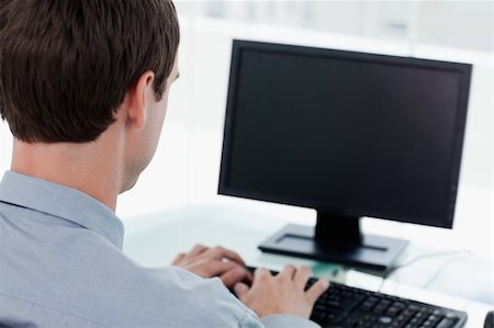 executives on table back - Back view of a businessman working with a computer in his office Stock Photo - Budget Royalty-Free & Subscription, Code: 400-05900847