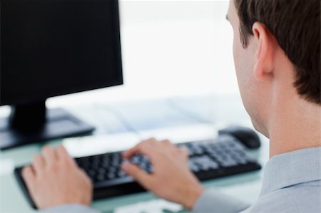 executives on table back - Back view of a businessman working with a monitor in his office Stock Photo - Budget Royalty-Free & Subscription, Code: 400-05900849