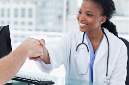 doctor patient shake hands - Smiling female doctor shaking a hand in her office Stock Photo - Budget Royalty-Free & Subscription, Code: 400-05900842