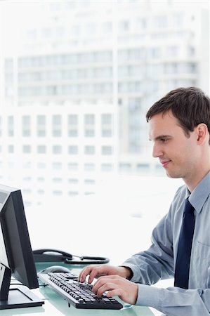 simsearch:400-05900668,k - Side view of an office worker using a monitor in his office Stock Photo - Budget Royalty-Free & Subscription, Code: 400-05900874
