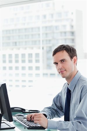 simsearch:400-05687698,k - Side view of a serious office worker using a monitor in his office Stock Photo - Budget Royalty-Free & Subscription, Code: 400-05900877