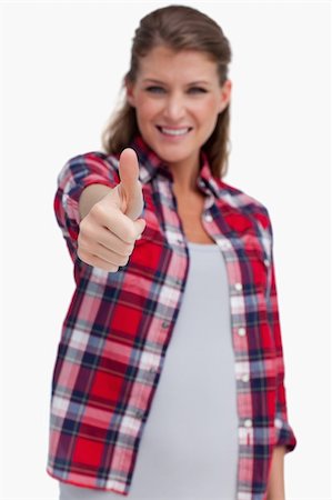 simsearch:400-06769983,k - Portrait of a young woman with the thumb up against a white background Foto de stock - Royalty-Free Super Valor e Assinatura, Número: 400-05900939