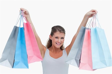 simsearch:400-06092781,k - Woman holding shopping bags against a white background Photographie de stock - Aubaine LD & Abonnement, Code: 400-05900984