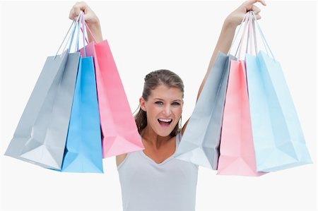 simsearch:400-06092781,k - Cheerful woman holding shopping bags against a white background Photographie de stock - Aubaine LD & Abonnement, Code: 400-05900985