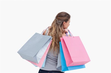 simsearch:400-06092781,k - Back view of a woman holding shopping bags against a white background Photographie de stock - Aubaine LD & Abonnement, Code: 400-05900987