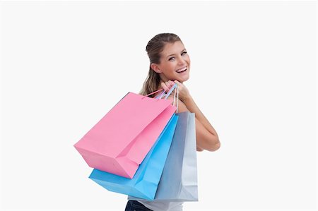 simsearch:400-06092781,k - Back view of a cheerful woman holding shopping bags against a white background Photographie de stock - Aubaine LD & Abonnement, Code: 400-05900988