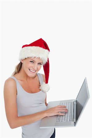 Woman with a Christmas hat using a notebook against a white background Stock Photo - Budget Royalty-Free & Subscription, Code: 400-05901054