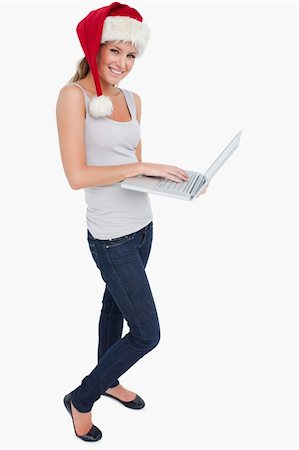 Portrait of a woman with a Christmas hat using a laptop against a white background Stock Photo - Budget Royalty-Free & Subscription, Code: 400-05901058