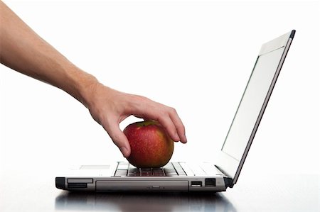 A hand reaching out and taking an apple from a laptop keyboard. Stock Photo - Budget Royalty-Free & Subscription, Code: 400-05901314