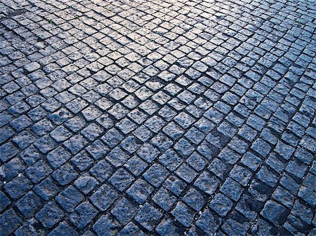 Square cobblestones, slightly polished from traffic, show a reflection from the sun at dusk on a street in the Alfama district of Lisbon. Stockbilder - Microstock & Abonnement, Bildnummer: 400-05901726