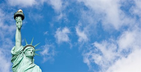 Sunnny day, blue sky with clouds: statue of Liberty with copy space Stock Photo - Budget Royalty-Free & Subscription, Code: 400-05902845