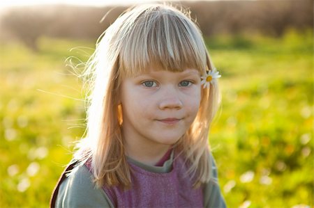 simsearch:400-06768635,k - Cute little girl outdoors on a green field with flower in her hair Foto de stock - Royalty-Free Super Valor e Assinatura, Número: 400-05903024