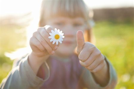 simsearch:400-06768635,k - Cute little girl outdoors on a green field with a flower and thumbs up Foto de stock - Royalty-Free Super Valor e Assinatura, Número: 400-05903026