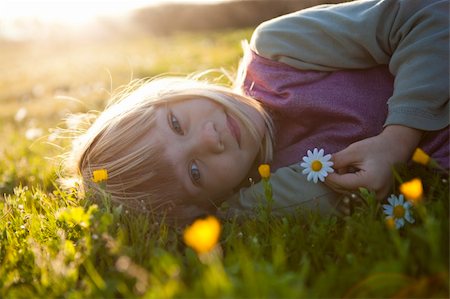 simsearch:400-06768635,k - Cute little girl outdoors on a green field with flowers Foto de stock - Royalty-Free Super Valor e Assinatura, Número: 400-05903027