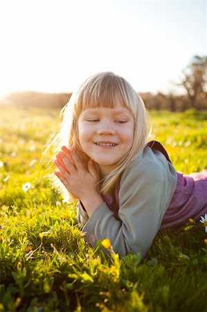 simsearch:400-06768635,k - Cute little girl outdoors on a green field with flowers Foto de stock - Royalty-Free Super Valor e Assinatura, Número: 400-05903028