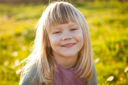 simsearch:400-06768635,k - Cute little girl outdoors on a green field with flowers Foto de stock - Royalty-Free Super Valor e Assinatura, Número: 400-05903029