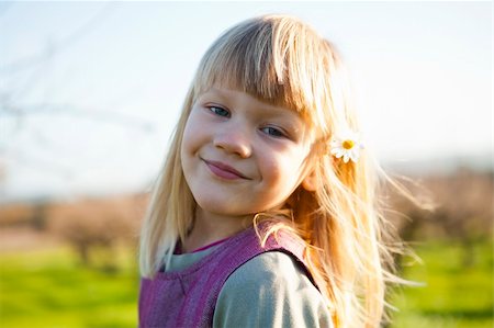 simsearch:400-06768635,k - Cute little girl outdoors on a green field with flower in her hair Foto de stock - Royalty-Free Super Valor e Assinatura, Número: 400-05903020