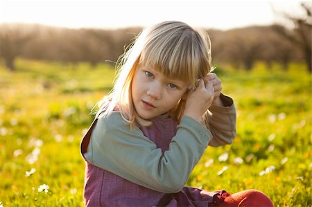 simsearch:400-06768635,k - Cute little girl outdoors on a green field with flower in her hair Foto de stock - Royalty-Free Super Valor e Assinatura, Número: 400-05903023