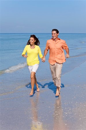 running marriage - Man and woman romantic couple running holding hands on a deserted tropical beach with bright clear blue sky Stock Photo - Budget Royalty-Free & Subscription, Code: 400-05903502