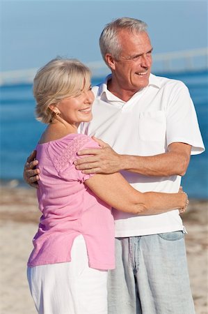 Happy senior man and woman couple together embracing and walking on a deserted tropical beach Stock Photo - Budget Royalty-Free & Subscription, Code: 400-05903512