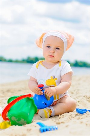 cute baby girl playing on the beach with sand. Vertical view Stock Photo - Budget Royalty-Free & Subscription, Code: 400-05914735