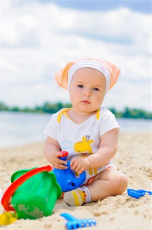 cute baby girl playing on the beach with sand. Vertical view Stock Photo - Budget Royalty-Free & Subscription, Code: 400-05914736