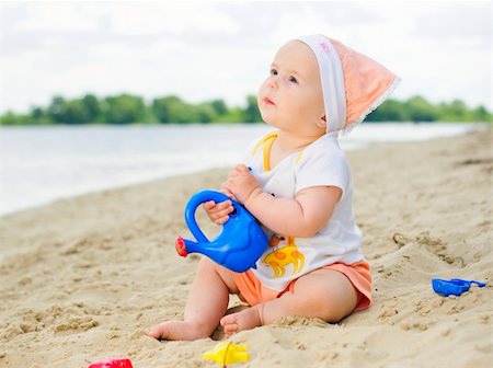 cute baby girl playing on the beach with sand. Foto de stock - Super Valor sin royalties y Suscripción, Código: 400-05914737