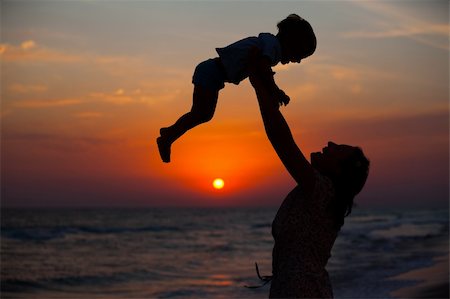 family holding hands on beach at sundown - Mother and little son silhouettes on beach at sunset Stock Photo - Budget Royalty-Free & Subscription, Code: 400-05914741