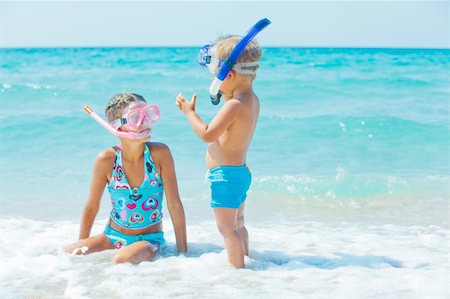 family relaxing with kids in the sun - Smiling Happy brother and sister posing on a beach wearing snorkeling equipment. In the background the sea Stock Photo - Budget Royalty-Free & Subscription, Code: 400-05914759