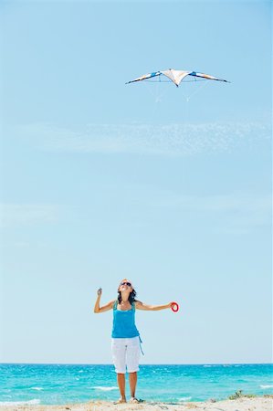 Young cute woman playing with a colorful kite on the tropical beach. Vertikal veiw Stock Photo - Budget Royalty-Free & Subscription, Code: 400-05916986