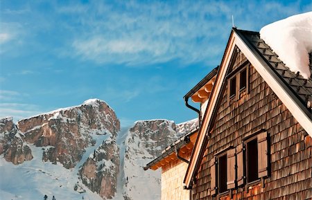 An alpine hut covered in snow in front of a mountain peak in winter Fotografie stock - Microstock e Abbonamento, Codice: 400-05917376