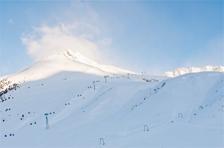 Blue sky and sunrise at a mountain in an alpine ski resort Fotografie stock - Microstock e Abbonamento, Codice: 400-05917377