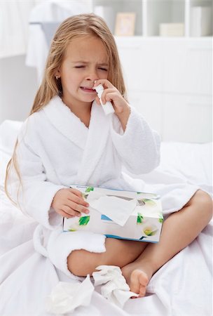 Little girl with a bad case of influenza using nasal spray and a box of paper tissues Stock Photo - Budget Royalty-Free & Subscription, Code: 400-05919448