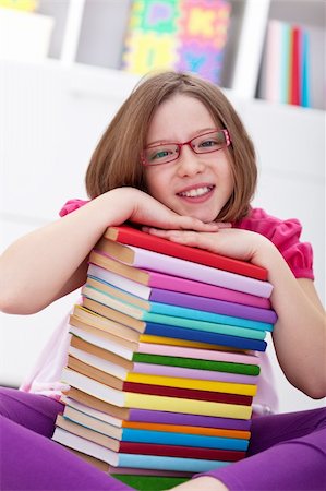 school girl holding pile of books - School girl sitting with lots of books smiling Stock Photo - Budget Royalty-Free & Subscription, Code: 400-05919494