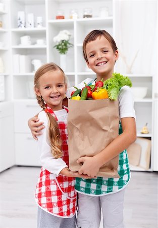 shopping bags in kitchen - Happy healthy kids in the kitchen with the grocery bag full of vegetables Stock Photo - Budget Royalty-Free & Subscription, Code: 400-05919520