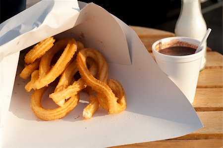 Churros with chocolate, crunchy traditional Spanish breakfast on a table at a street stall. Stock Photo - Budget Royalty-Free & Subscription, Code: 400-05919995