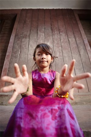 Portrait of cute Asian female child in pink dress pointing hands at camera Foto de stock - Super Valor sin royalties y Suscripción, Código: 400-05910401