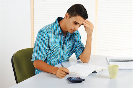 student latino business casual - Young man trying to study with a headache. Stock Photo - Budget Royalty-Free & Subscription, Code: 400-05910570