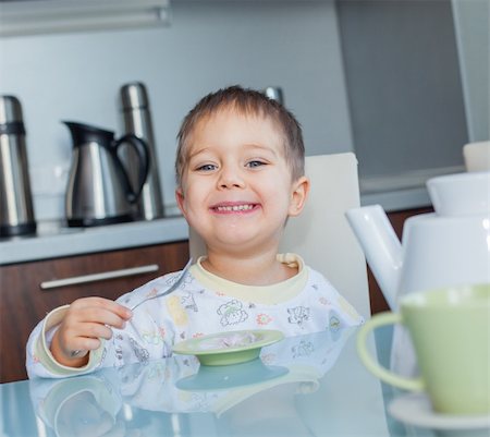 simsearch:400-05014700,k - Happy little cute boy in pajamas eating breakfast at a table in the kitchen Fotografie stock - Microstock e Abbonamento, Codice: 400-05910626