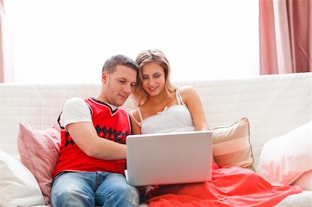 Happy young woman with husband working on laptop Stock Photo - Budget Royalty-Free & Subscription, Code: 400-05911636