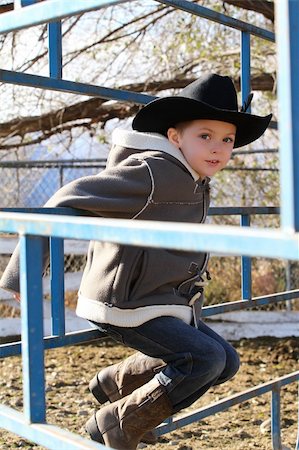fence cowboy - Young cowboy wearing a hat and fleece jacket Stock Photo - Budget Royalty-Free & Subscription, Code: 400-05911838