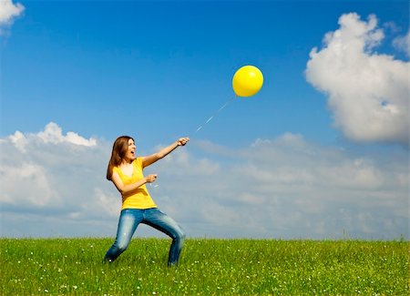 simsearch:400-08262183,k - Happy young woman holding a yellow balloon with strenght Stock Photo - Budget Royalty-Free & Subscription, Code: 400-05912307