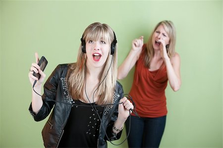 daughter angry - Teen singing out loud with frustrated mom behind her Stock Photo - Budget Royalty-Free & Subscription, Code: 400-05913568