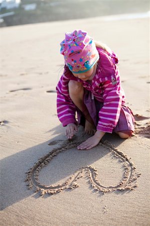 Cute little girl drawing a heart in sand with hands Photographie de stock - Aubaine LD & Abonnement, Code: 400-05924049