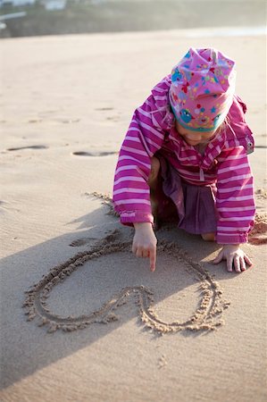 Cute little girl drawing a heart in sand with hands Stock Photo - Budget Royalty-Free & Subscription, Code: 400-05924050