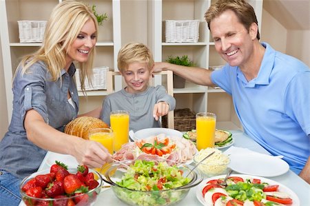 simsearch:400-04327229,k - An attractive happy, smiling family of mother, father and son eating salad and healthy food at a dining table Stock Photo - Budget Royalty-Free & Subscription, Code: 400-05932504